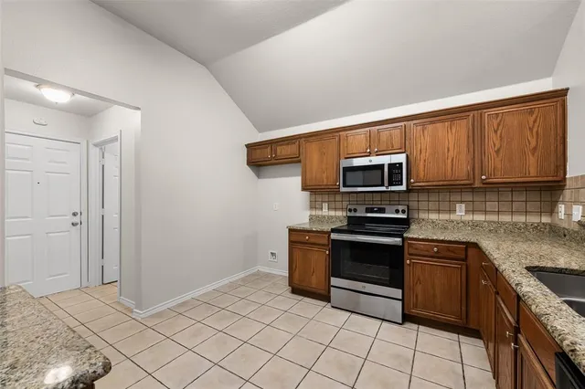 a kitchen with stainless steel appliances granite countertop a stove a sink and a microwave