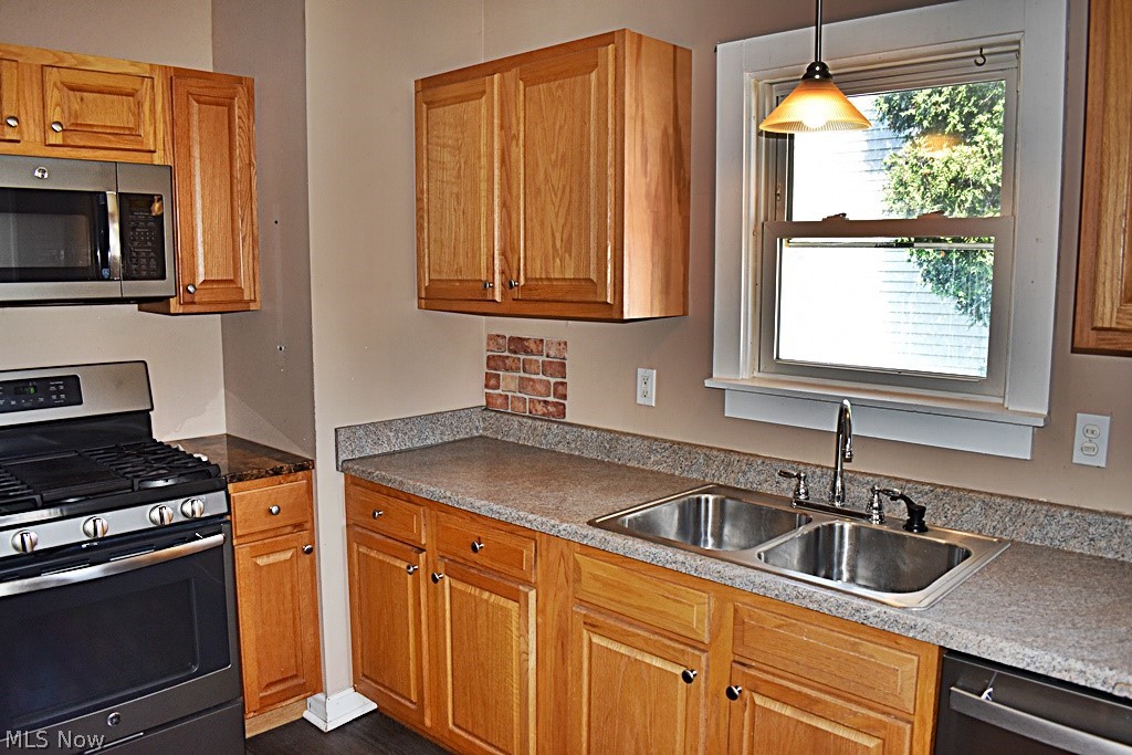7715 Ackley Road Parma, OH 44129 - Photo 10 of 27 Kitchen with appliances with stainless steel finishes, decorative light fixtures, and sink