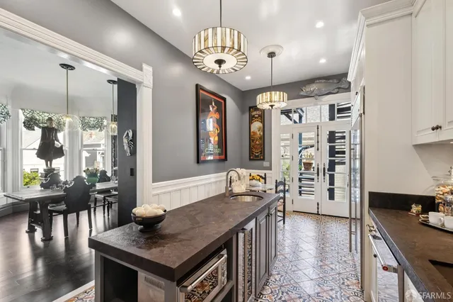 a kitchen with stainless steel appliances kitchen island granite countertop a refrigerator a sink and a stove