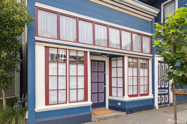 a bedroom with a bed a table and windows