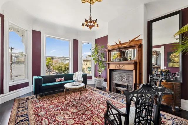 a living room with furniture a rug a fireplace and a large window