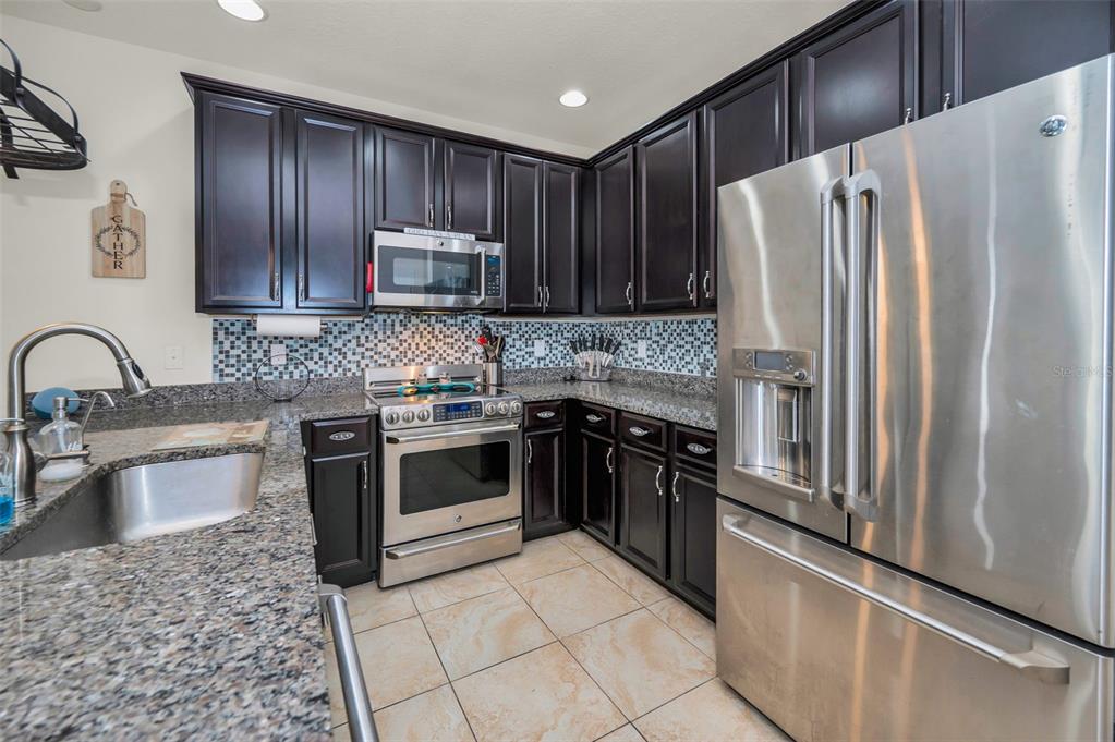 5529 White Marlin Court New Port Richey, FL 34652 - Photo 26 of 63 a kitchen with granite countertop a refrigerator stove and sink
