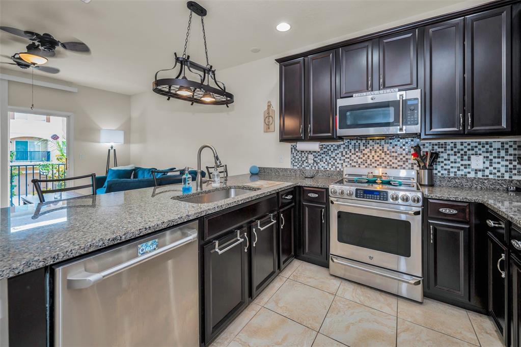 5529 White Marlin Court New Port Richey, FL 34652 - Photo 27 of 63 a kitchen with stainless steel appliances granite countertop a sink stove and refrigerator