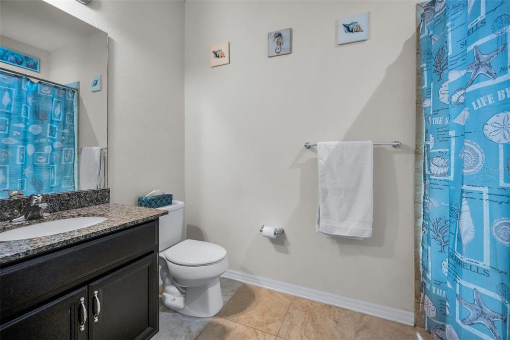 5529 White Marlin Court New Port Richey, FL 34652 - Photo 43 of 63 a bathroom with a granite countertop sink toilet a mirror and shower