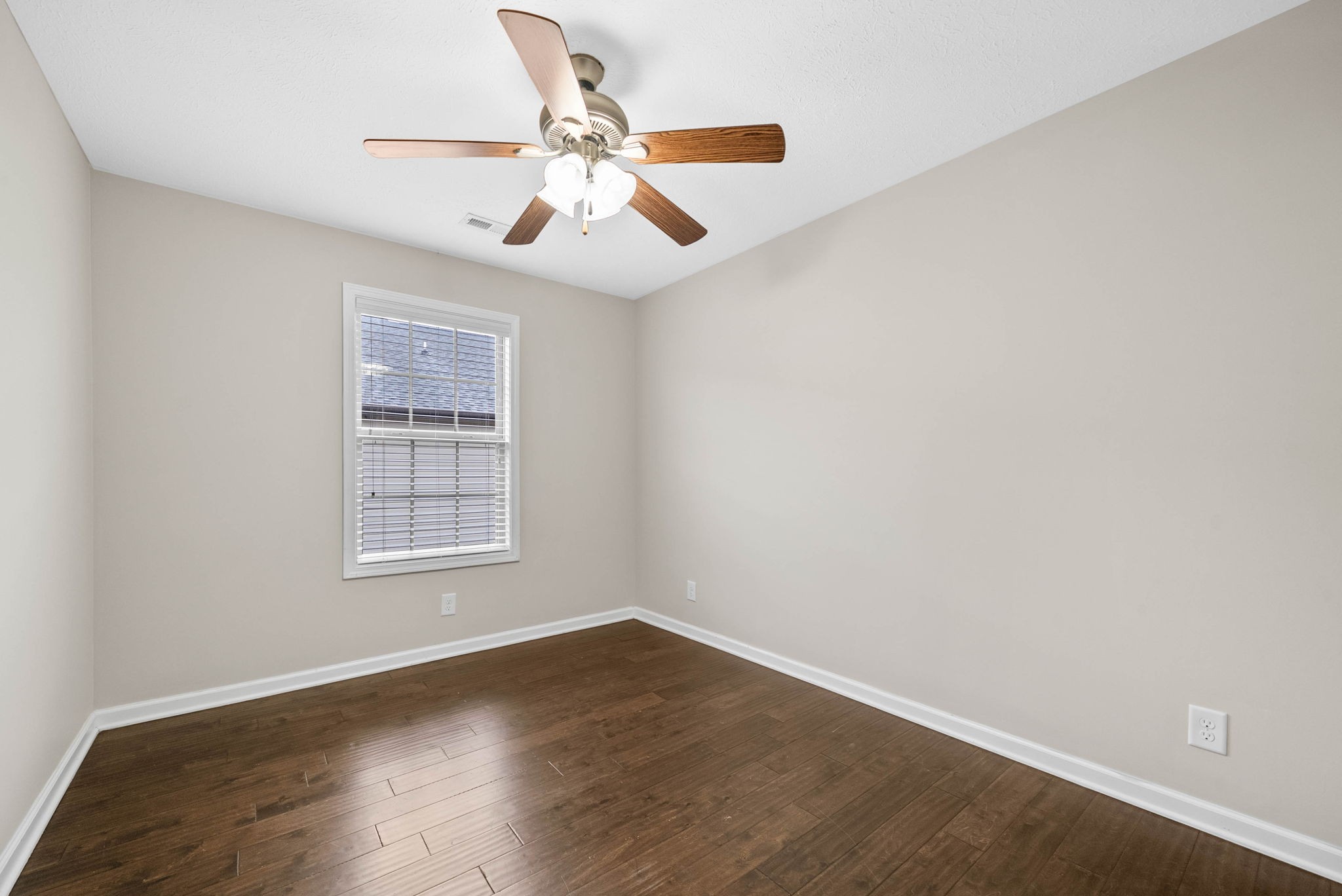 133 Melbourne Drive, Unit E Clarksville, TN 37043 - Photo 14 of 16 an empty room with wooden floor chandelier fan and windows
