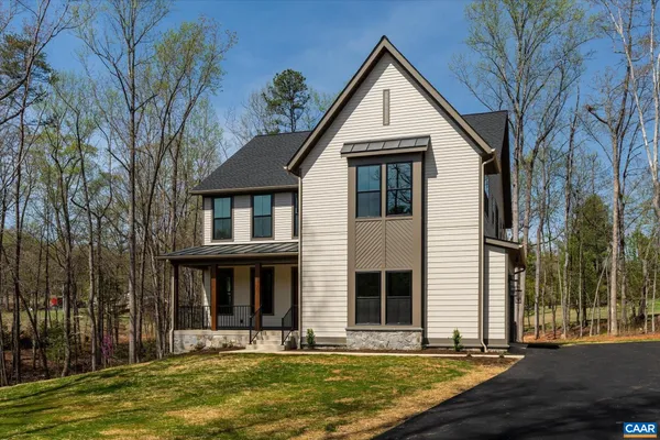 a view of a white house with large windows and a tree