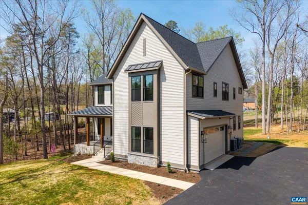 a view of an empty room with wooden floor fireplace and a window