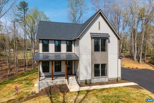 a view of a livingroom with wooden floor fireplace and windows