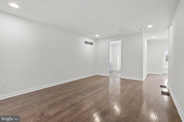 a view of an empty room with wooden floor