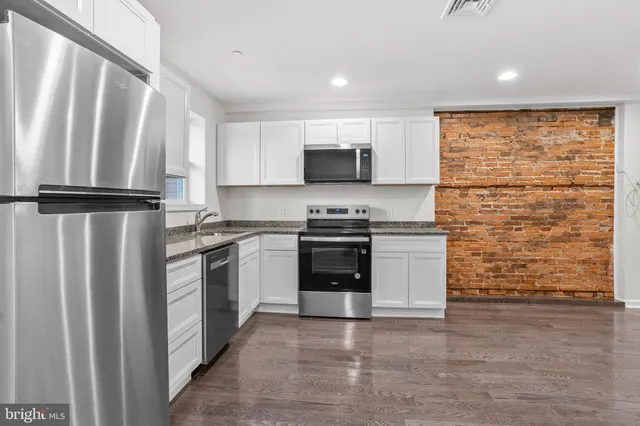 a kitchen with stainless steel appliances a refrigerator sink and microwave