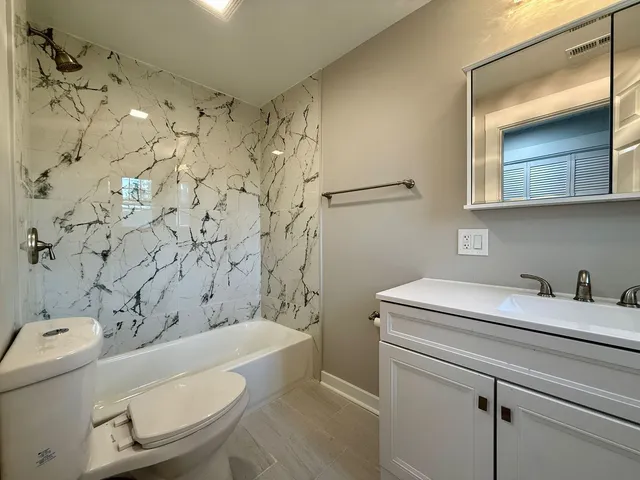a bathroom with a sink toilet vanity and shower