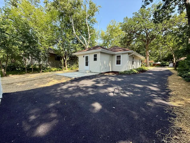 a front view of a house with a yard and trees