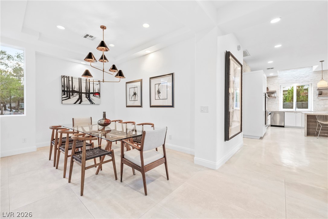2000 Grouse Street Las Vegas, NV 89134 - Photo 17 of 89 A chic dining area with a glass-top table anchors this open-concept layout, flowing seamlessly into a modern kitchen.