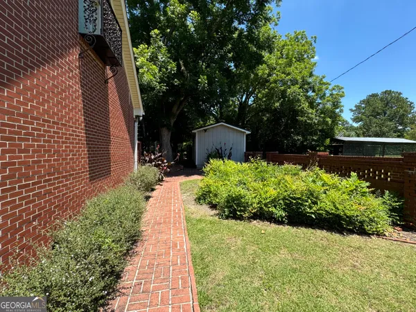 a view of a yard with plants and trees