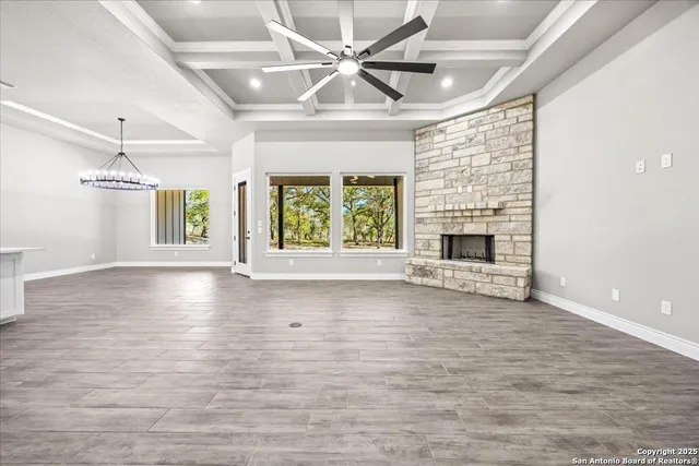 an empty room with windows and fireplace