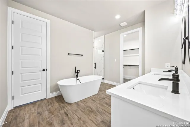 a spacious bathroom with a tub sink and mirror