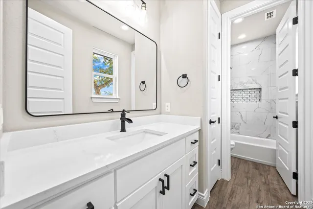 a bathroom with a sink a mirror and a shower