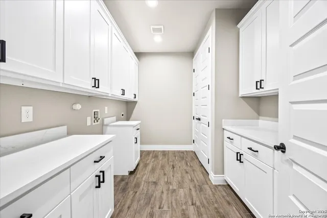 a view of a kitchen with cabinets and wooden floor