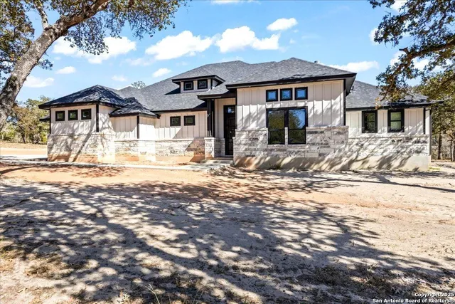 a front view of a house with a yard covered in snow