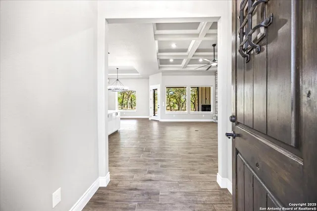 a view of a hallway with wooden floor and a window