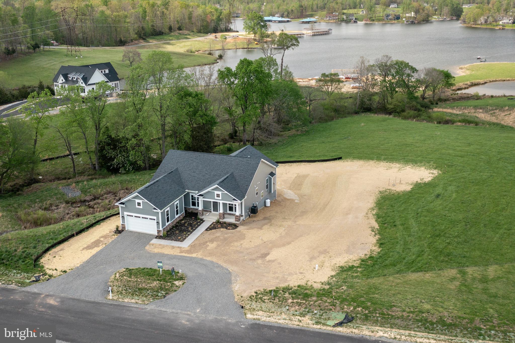 an aerial view of a house with outdoor space lake view and a yard