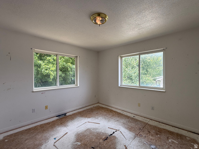 838 East Mountain Road Logan, UT 84321 - Photo 21 of 37 Room featuring two large windows with white trim, a semi-flush mount ceiling light fixture, and raw subflooring