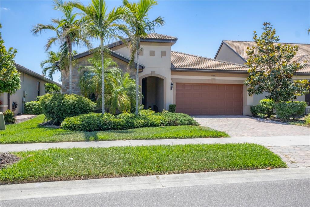 13841 RINUCCIO Street Venice, FL 34293 - Photo 1 of 1 a front view of a house with a garden and yard