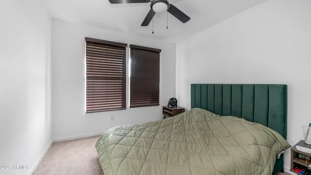 a bed sitting in a bedroom next to a window and a chandelier