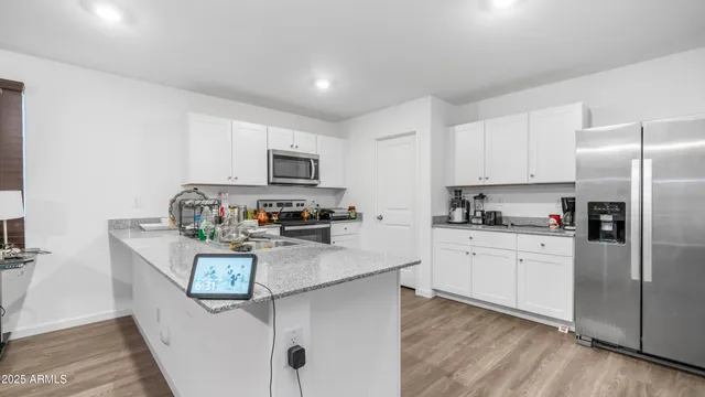 a kitchen with stainless steel appliances granite countertop a refrigerator a stove top oven a sink and dishwasher