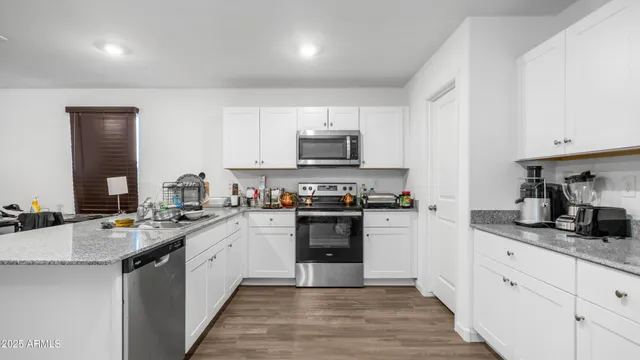 a kitchen with stainless steel appliances granite countertop a stove sink and cabinets