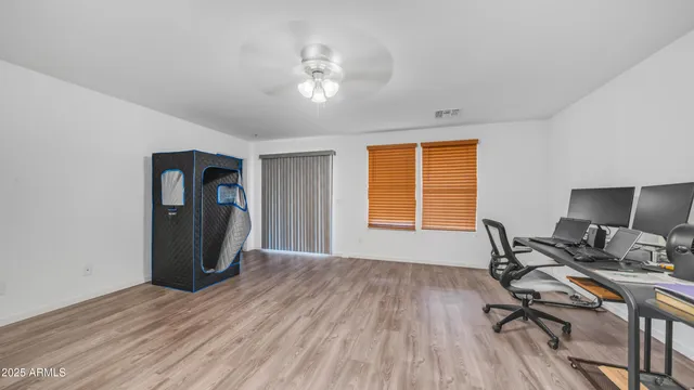 a view of a workspace with furniture and a window