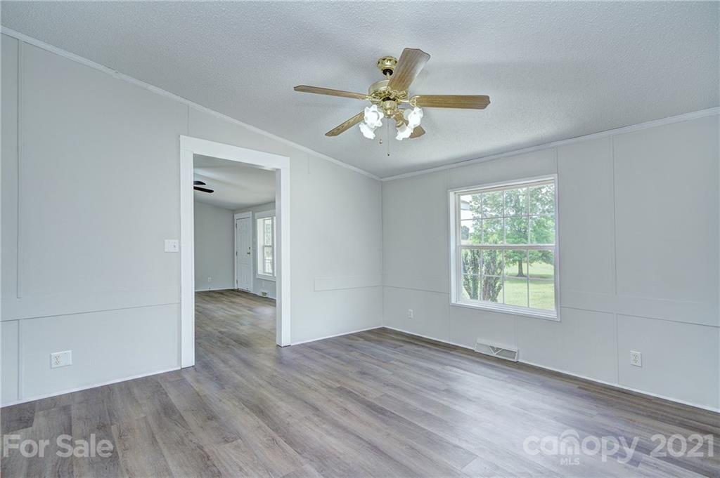7918 Morgan Mill Road Monroe, NC 28110 - Photo 11 of 37 a view of an empty room with a window and wooden floor