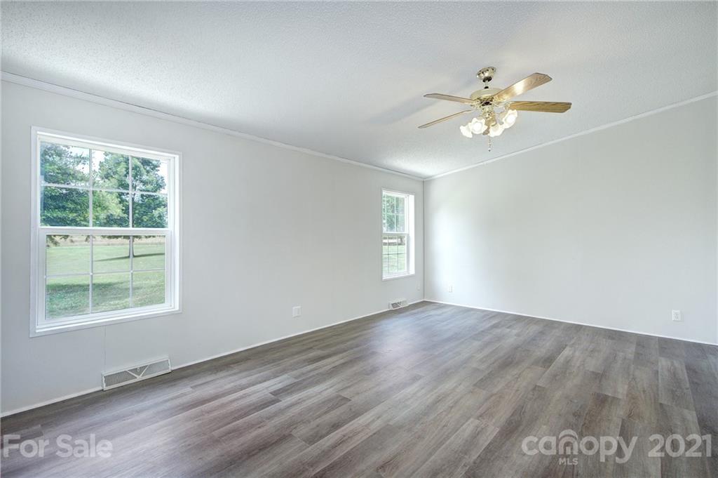7918 Morgan Mill Road Monroe, NC 28110 - Photo 16 of 37 a view of an empty room with a window and wooden floor