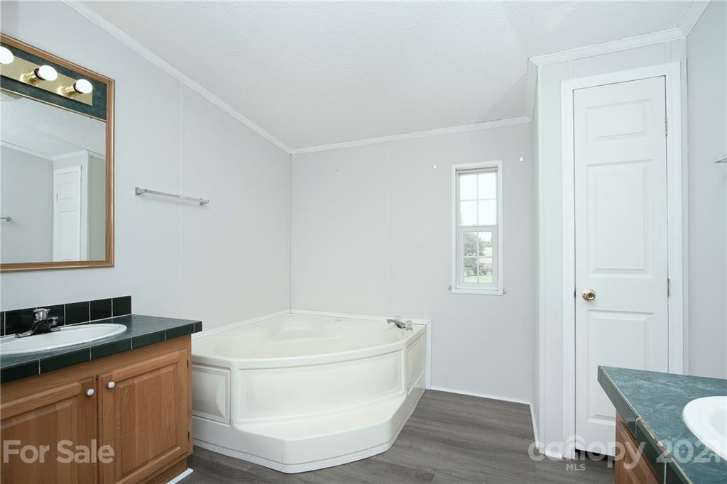 7918 Morgan Mill Road Monroe, NC 28110 - Photo 19 of 37 a bathroom with a granite countertop sink and a mirror