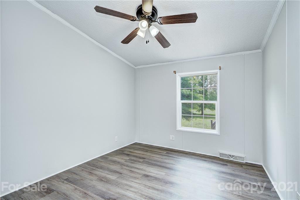7918 Morgan Mill Road Monroe, NC 28110 - Photo 21 of 37 an empty room with a window and a ceiling fan