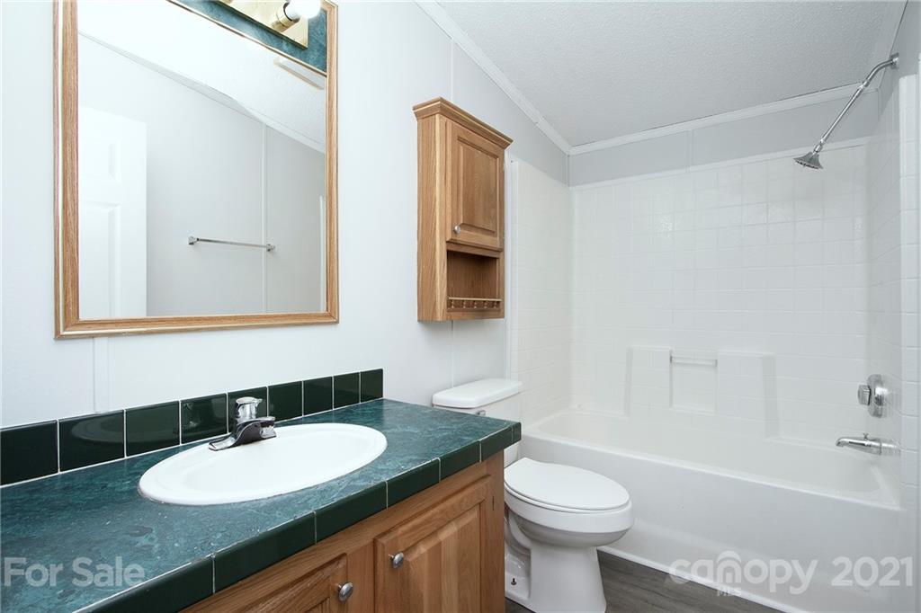7918 Morgan Mill Road Monroe, NC 28110 - Photo 22 of 37 a bathroom with a granite countertop sink toilet and a mirror