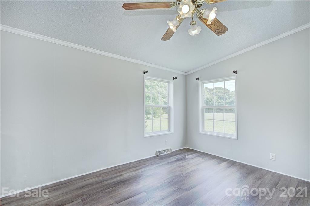 7918 Morgan Mill Road Monroe, NC 28110 - Photo 23 of 37 a view of an empty room with wooden floor and a window