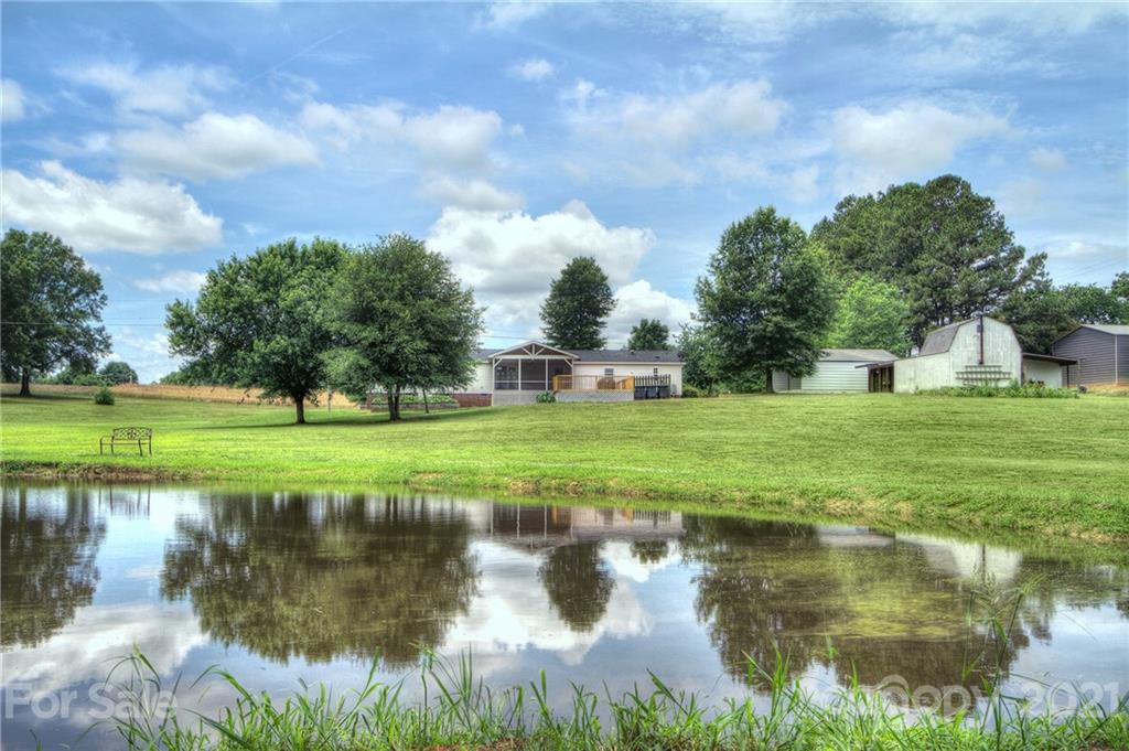 7918 Morgan Mill Road Monroe, NC 28110 - Photo 36 of 37 a view of a lake with a yard and large trees