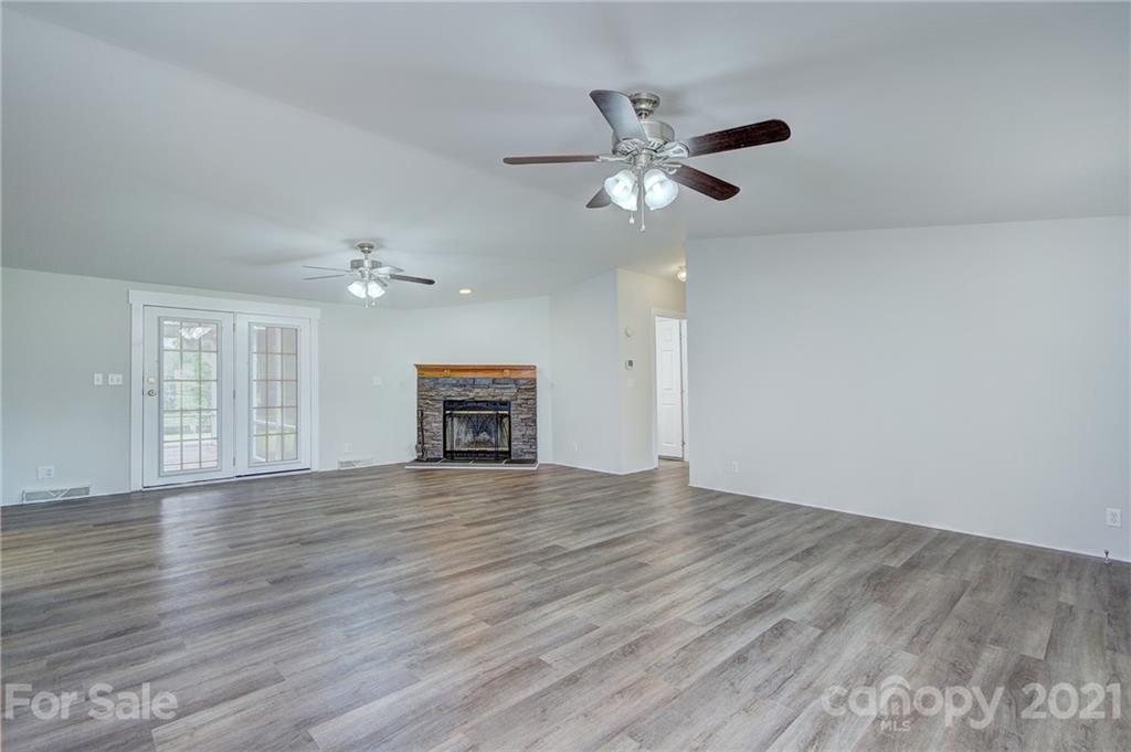 7918 Morgan Mill Road Monroe, NC 28110 - Photo 8 of 37 a view of an empty room with wooden floor and a ceiling fan