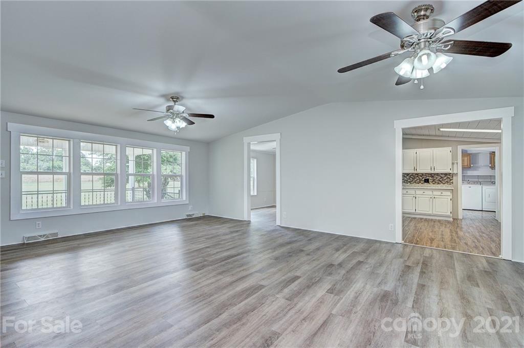 7918 Morgan Mill Road Monroe, NC 28110 - Photo 9 of 37 a view of an empty room with a window and wooden floor