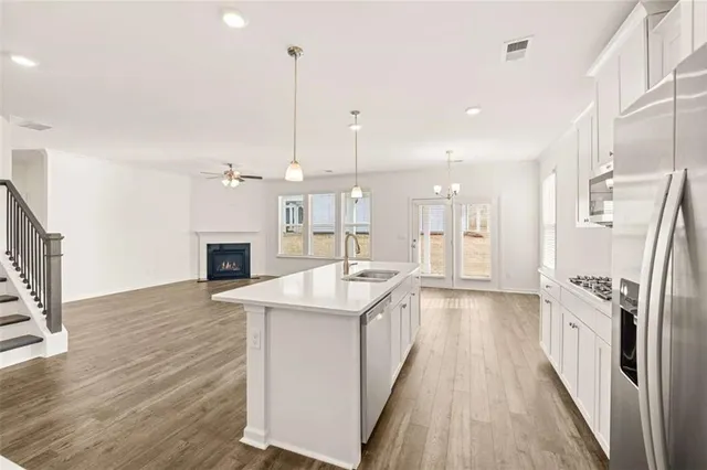 a view of an empty room with wooden floor fireplace and a window