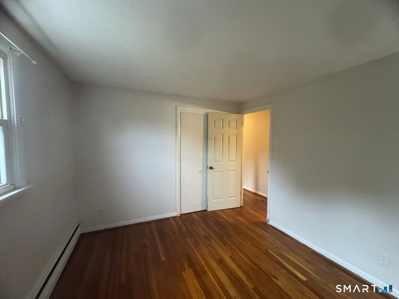 1122 Fienemann Road Farmington, CT 06032 - Photo 10 of 26 a view of an empty room with wooden floor and a window