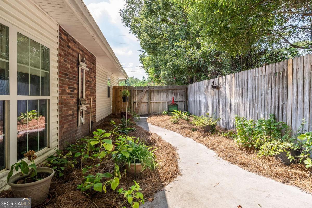 1238 Red Keen Road Waycross, GA 31503 - Photo 33 of 37 a view of a backyard with potted plants and a chair