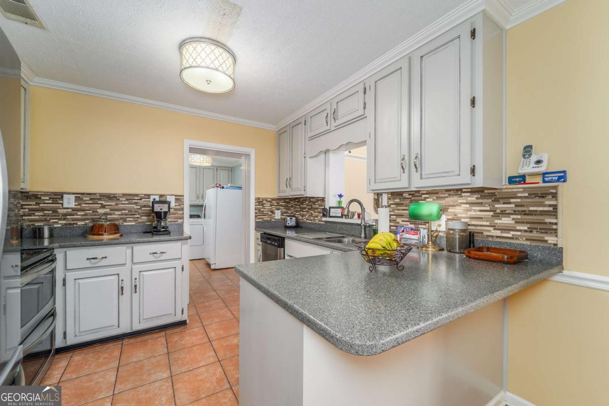 1238 Red Keen Road Waycross, GA 31503 - Photo 8 of 37 a kitchen with stainless steel appliances granite countertop a sink stove and cabinets