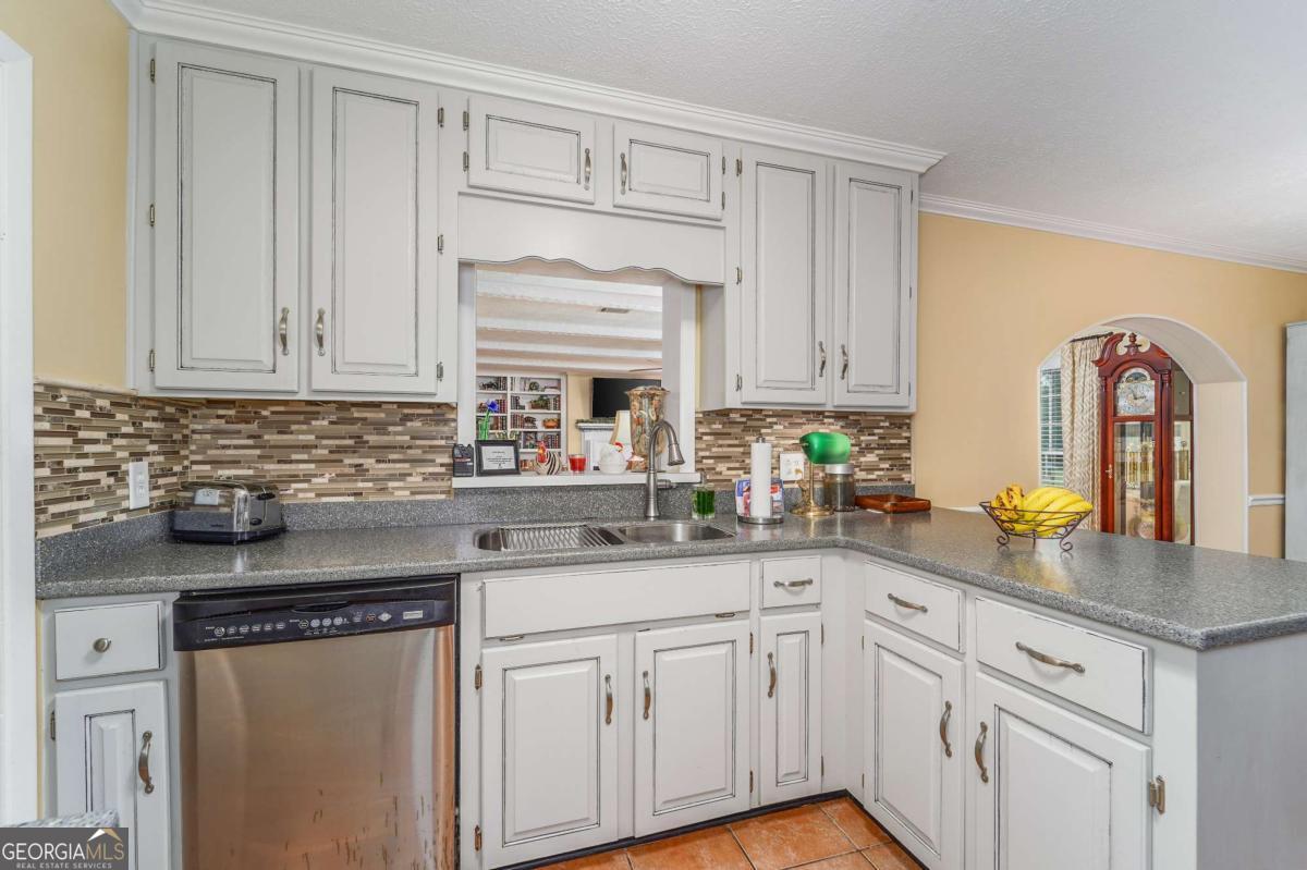 1238 Red Keen Road Waycross, GA 31503 - Photo 9 of 37 a kitchen with granite countertop white cabinets and white appliances
