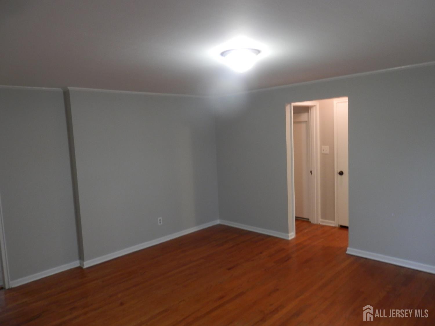 39A Garfield Park, Unit B Edison, NJ 08837 - Photo 6 of 11 an empty room with wooden floor and windows