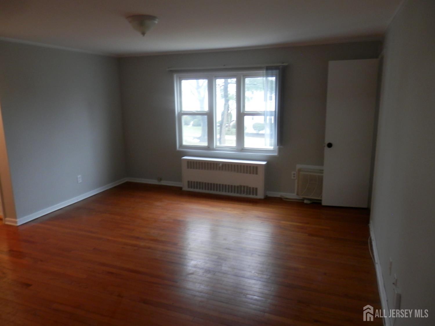 39A Garfield Park, Unit B Edison, NJ 08837 - Photo 8 of 11 an empty room with wooden floor and windows