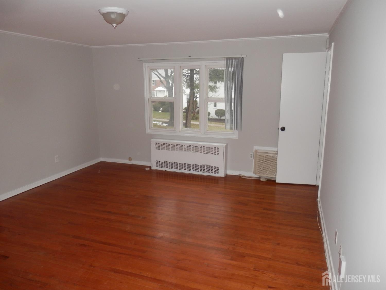 39A Garfield Park, Unit B Edison, NJ 08837 - Photo 9 of 11 an empty room with wooden floor and windows