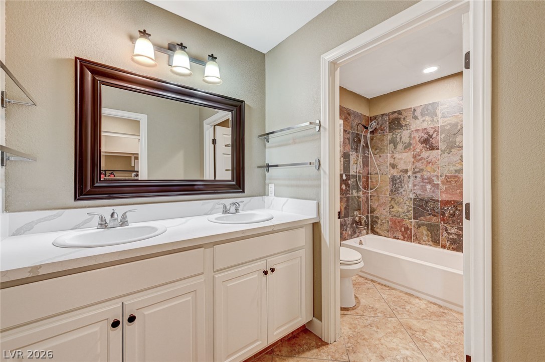 4153 Woodcrest Road Las Vegas, NV 89121 - Photo 20 of 58 Double vanity offers ample space, complementing the tiled shower and bath for daily routines.