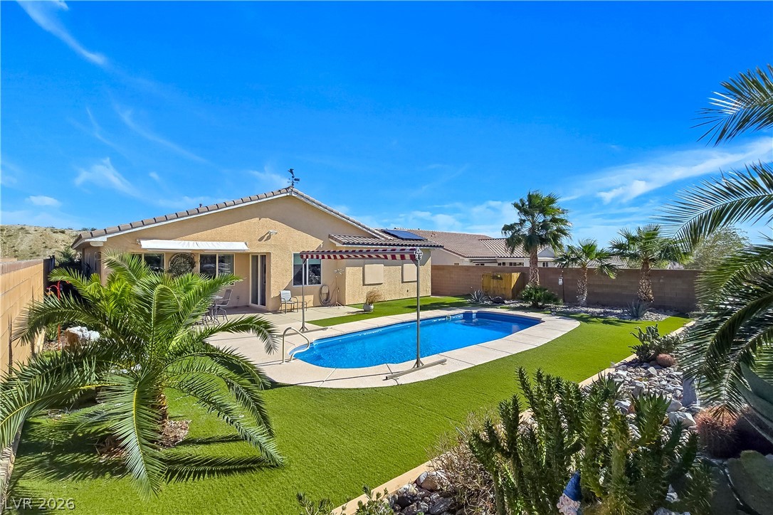 2485 Morrow Ridge Place Laughlin, NV 89029 - Photo 33 of 40 A desert oasis awaits with a glistening swimming pool and lush artificial turf.